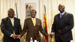 President Robert Mugabe, centre, shares a light moment with Morgan Tsvangirai, left, Zimbabwe's Prime Minister and his Deputy, Arthur Mutambara after giving their end of year message to the nation, at Zimbabwe House in Harare, Wednesday, Dec. 23, 2009. Th