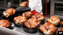 FILE - In this May 8, 2008, file photo, a butcher spreads out rotisserie-roasted chicken at Costco in Mountain View, California. (AP Photo/Paul Sakuma, File)