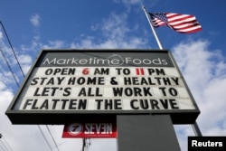 A neighborhood market marquee reads "stay home and healthy, lets all work to flatten the curve" in Seattle, Washington, U.S. April 2, 2020. (REUTERS/Jason Redmond)