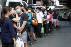 People wait along a street to buy protective face masks at a store in Manila, Philippines on Thursday, Jan. 30, 2020. Health Secretary Francisco Duque confirmed the Philippines' first case of a new virus that has infected thousands in China. (AP Photo)