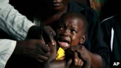 FILE - A boy reacts as he receives a yellow fever vaccine injection in the Kisenso district of Kinshasa, DRC, July 21, 2016.