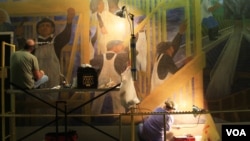Conservators at work in July 2012 on the West Wall of The Meaning of Social Security