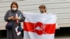Белоруски развернули бело-красно-белый стяг с японской символикой рядом с посольством Польши в Токио, ожидая прибытия белорусской легкоатлетки Кристины Тимановской, 2 августа 2021 года
