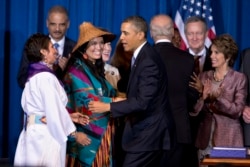 FILE - President Barack Obama greets Our Sisterís Keeper Executive Director Diane Millich, from left, and Tulalip Tribes of Washington State Vice Chairwoman Deborah Parker, after signing the Violence Against Women Act in Washington, D.C., March 7, 2013.