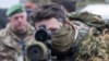 A British soldier looks into a telescopic sight as he holds his sniper rifle during the NATO DRAGON-24 military exercise in Korzeniewo, northern Poland, March 4, 2024.