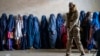 (FILE) Militer Taliban berjaga-jaga sementara para perempuan menunggu antrian makanan di Kabul, Afghanistan.
