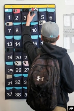 นักเรียนที่โรงเรียนมัธยมปลาย เดลตา (Delta High School) ในรัฐยูทาห์ นำโทรศัพท์มือถือของเธอใส่ไว้ในแผงใส่โทรศัพท์หน้าห้องเรียน (AP Photo/Rick Bowmer)