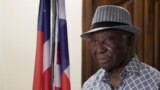 FILE PHOTO: Liberia president-elect Joseph Boakai looks on next to a Liberian flag, in Monrovia