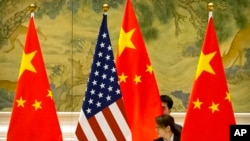 资料照： 在北京钓鱼台国宾馆，中方工作人员在美中贸易谈判开始前摆放两国国旗（2019年2月14日）