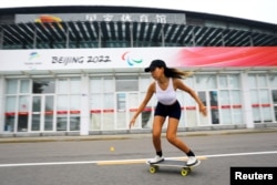 Duo Lan, 31, founder of Beijing Girls Surfskating Community, rides a skateboard during a free weekly training session, outside the National Sports Stadium in Beijing, China June 19, 2022. (REUTERS/Tingshu Wang)
