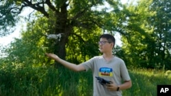 Andriy Pokrasa, 15, lands his drone on his hand during an interview with The Associated Press in Kyiv, Ukraine, Saturday, June 11, 2022. (AP Photo/Natacha Pisarenko)
