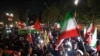2024年4月14日，伊朗对以色列发动无人机和导弹袭击后，示威者聚集在英国驻德黑兰大使馆前，挥舞着伊朗国旗和巴勒斯坦国国旗。