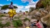 FILE - Joyce Ngui, left, fetches groundwater in Athi River, Machakos county, Kenya, Oct. 17, 2023