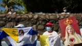 Peregrinos sostienen banderas mientras participan en un evento de la Virgen de Fátima el 13 de agosto de 2022 REUTERS/Maynor Valenzuela
