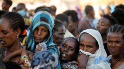 FILE - Ethiopian refugees line up for supplies at the Um Rakouba refugee camp, which houses refugees fleeing the fighting in the Tigray region, on the Sudan-Ethiopia border in Sudan, Nov. 29, 2020. 