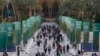 Orang-orang berjalan melalui spanduk KTT Perubahan Iklim PBB COP28, di Dubai, Uni Emirat Arab (4/12). (Foto AP/Peter Dejong)
