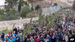 Ribuan umat Kristiani berjalan dalam prosesi "Minggu Palma" di Bukit Zaitun di Yerusalem timur, Minggu, 24 Maret 2024. 