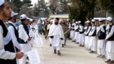 Sejumlah siswa memegang bendera Taliban ketika menyambut otoritas yang datang berkunjung Sekolah Menengah Amani di Kabul pada 20 Maret 2024 dalam upacara peringatan tahun ajaran baru. (Foto: AFP/Wakil Kohsar)
