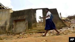 A school girl walks past houses that were demolished on public health grounds in the Gesco neighborhood of Abidjan, Ivory Coast, Feb. 28, 2024.