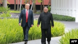 FILE - North Korea's leader Kim Jong Un, right, walks with U.S. President Donald Trump at the Capella Hotel on Sentosa island in Singapore, in this picture taken June 12, 2018, and released from North Korea's Korean Central News Agency. 