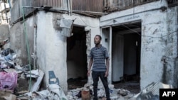 FILE —A man poses for a photograph outside his house during a planned demolition in the historical Piazza neighborhood of Addis Ababa on March 17, 2024.