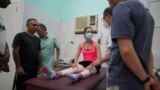 A ballet dancer speaks to Chilean Kinesiologist Mauro Model in a physiotherapy room at a ballet's school in Havana, Cuba, August 18, 2022. (REUTERS/Alexandre Meneghini)