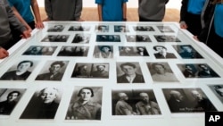 Група школярів навколо виставки фотографій в’язнів ГУЛАГу та жертв Великого терору, яка проходила в галереї Tate Modern. Виставка «Червона зірка над Росією» в Лондоні,  7 листопада 2017 року була присвячена сторіччю Жовтневої революції . (AP Photo/Kirsty Wigglesworth)