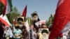 2024年4月19日，在午间祈祷后，伊朗人在德黑兰举行的反以色列示威活动中挥舞着巴勒斯坦和伊朗国旗。