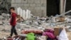 2024 年 3 月 26 日，以色列与激进组织哈马斯在巴勒斯坦领土上持续发生冲突，以色列轰炸加沙地带南部拉法。一名男孩站在从被炸的一栋大楼中搜寻出来的物品旁。