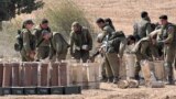 Israeli army soldiers handle artillery shells at a position near the Gaza Strip in southern Israel on October 12, 2023.