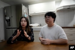 Yoo Young Yi speaks as her husband Jo Jun Hwi listens during an interview at their home in Seoul, South Korea on October 2, 2022. (AP Photo/Ahn Young-joon)