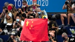 资料照片：2020东京奥运会一场游泳项目决赛的领奖台上飘扬着的中国国旗。（2021年7月29日）