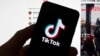 Le logo TikTok est visible sur un téléphone portable devant un écran d'ordinateur qui affiche l'écran d'accueil de TikTok, samedi 18 mars 2023, à Boston. (AP Photo/Michael Dwyer, File)