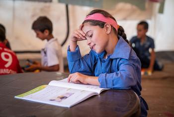A young Syrian refugee in Jordan studies at a UNICEF-supported centre.
