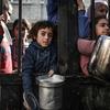 In Gaza, children wait to receive food as the bombardments on the enclave continue. 