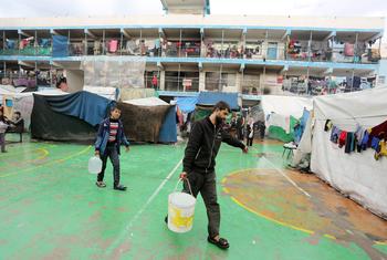 A man and boy collect water at a shelter for people displaced by the conflict in Gaza. (file)