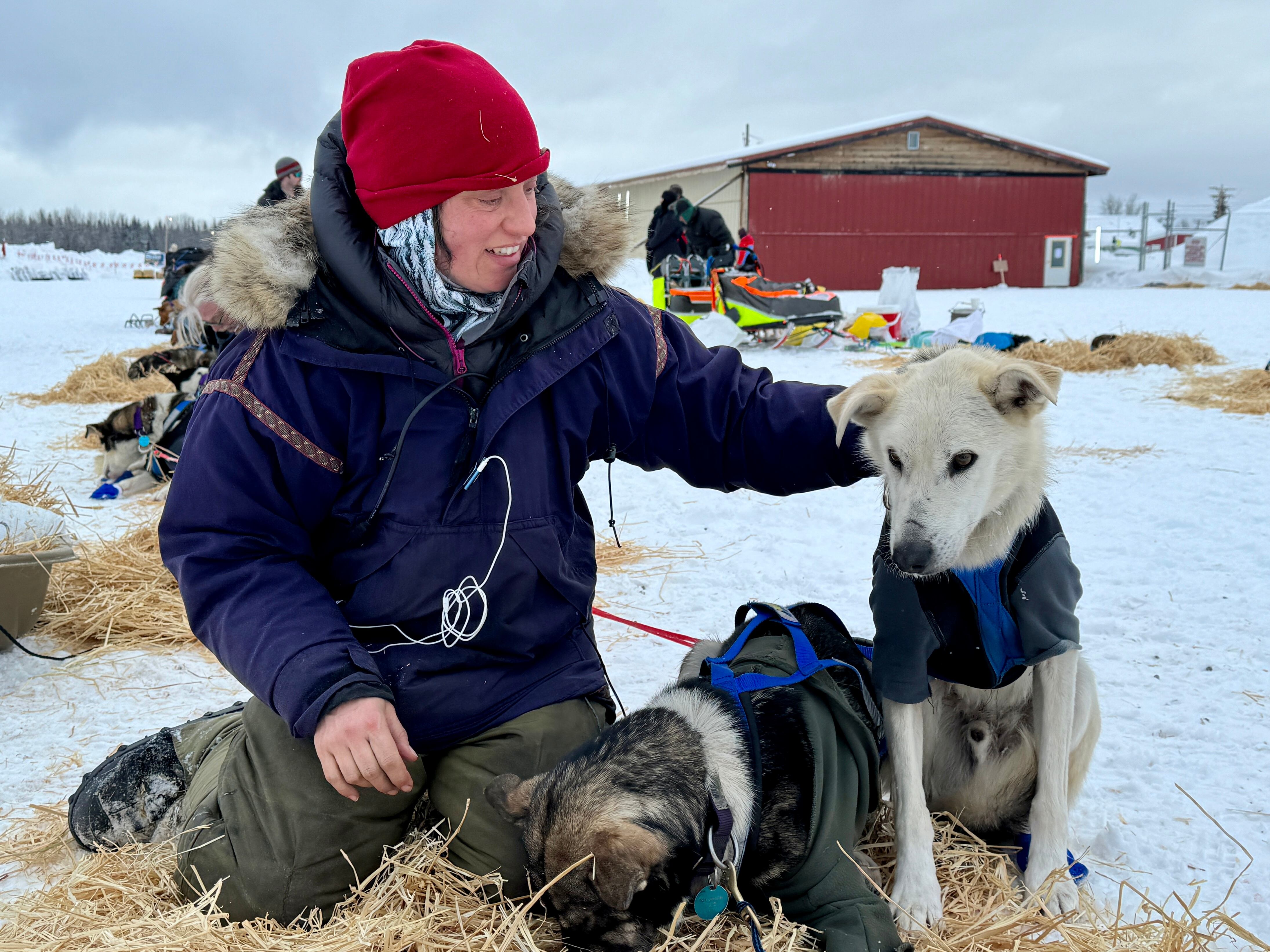 Rookie musher Erin Altemus poses with her dogs in McGrath at mile 311 along the Iditarod Trail.