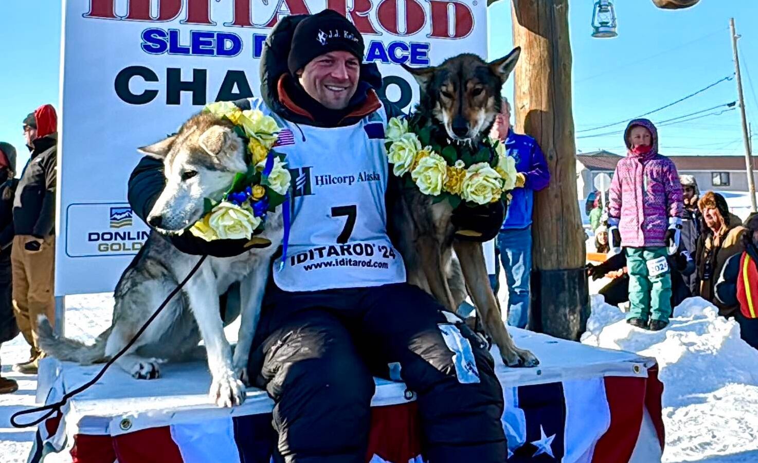 Dallas Seavey poses with two of his team members at the Iditarod finish line after winning his...