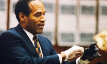 O.J. Simpson tries on a leather glove allegedly used in the murders of Nicole Brown Simpson and Ronald Goldman during testimony in Simpson's murder trial on June 15, 1995 in Los Angeles