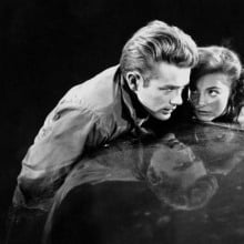 James Dean and Natalie Wood huddle together on the bonnet of a car in the film "Rebel Without a Cause".