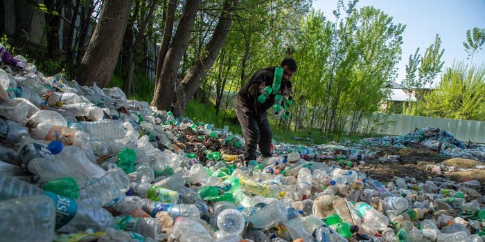 A waste worker in Srinagar, India sorts and collects plastic for recycling.