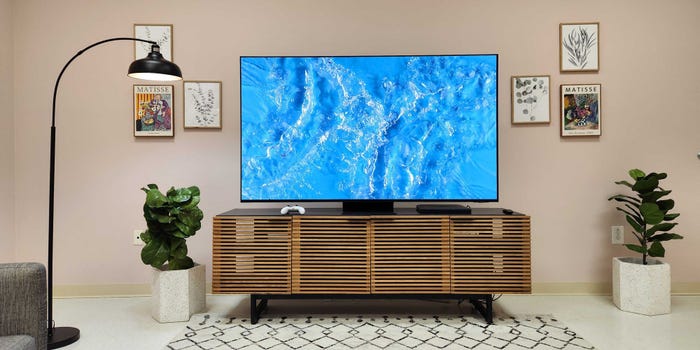 A Samsung S95D TV in a living room with a video of rippling water on the screen.