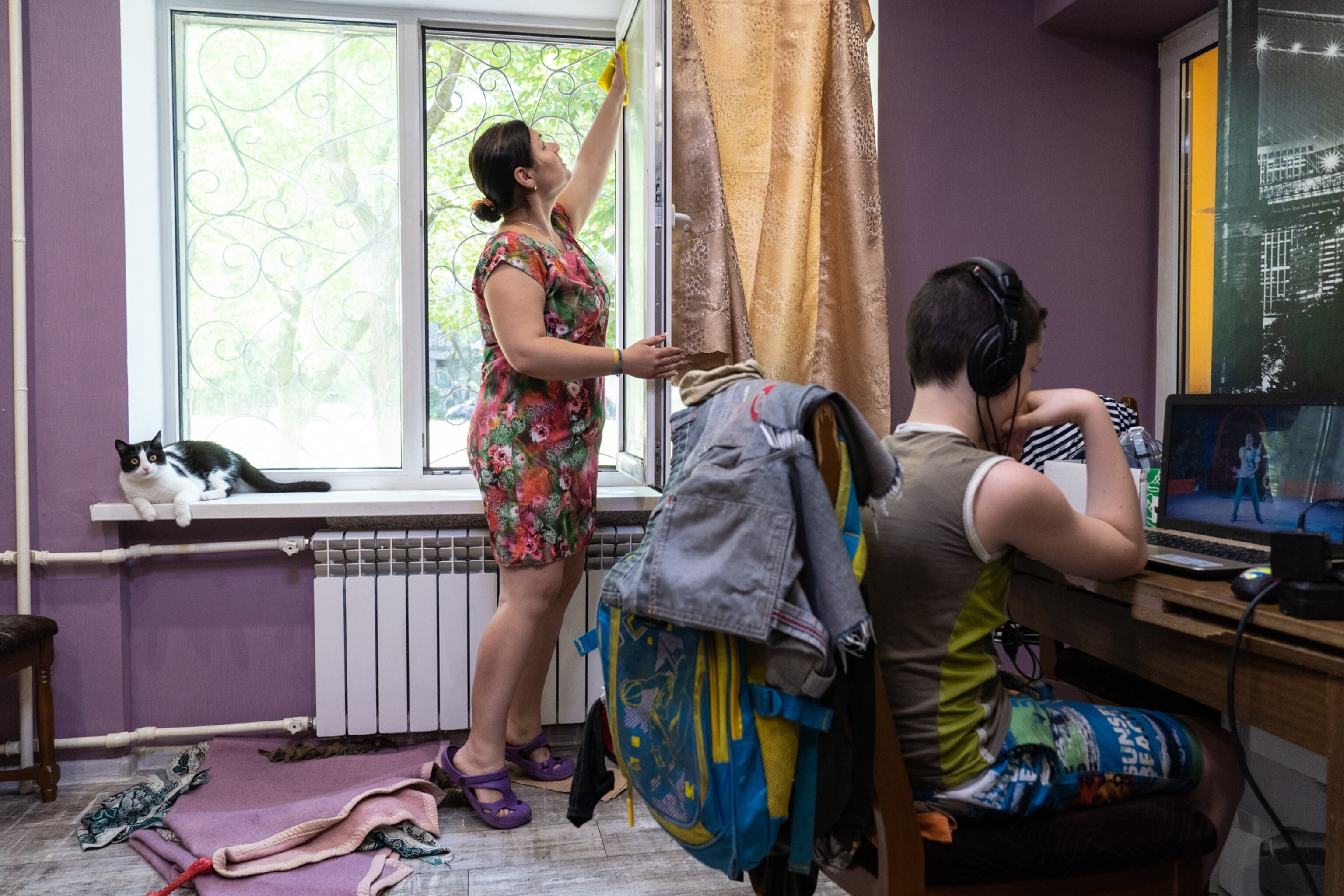 a woman cleans windows in her home which are covered with graphite dust