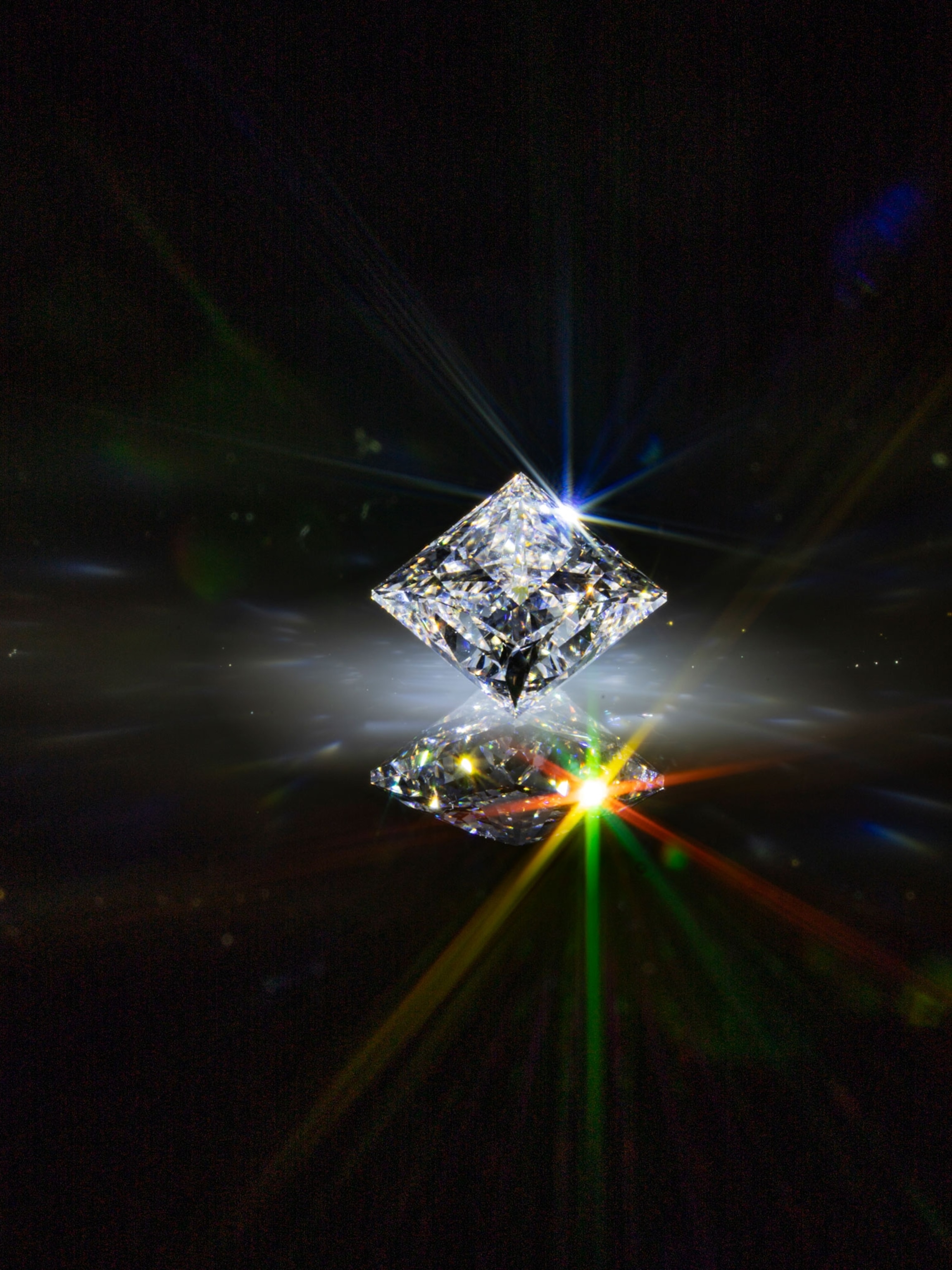 a synthetic diamond reflects rainbow shine on a black background