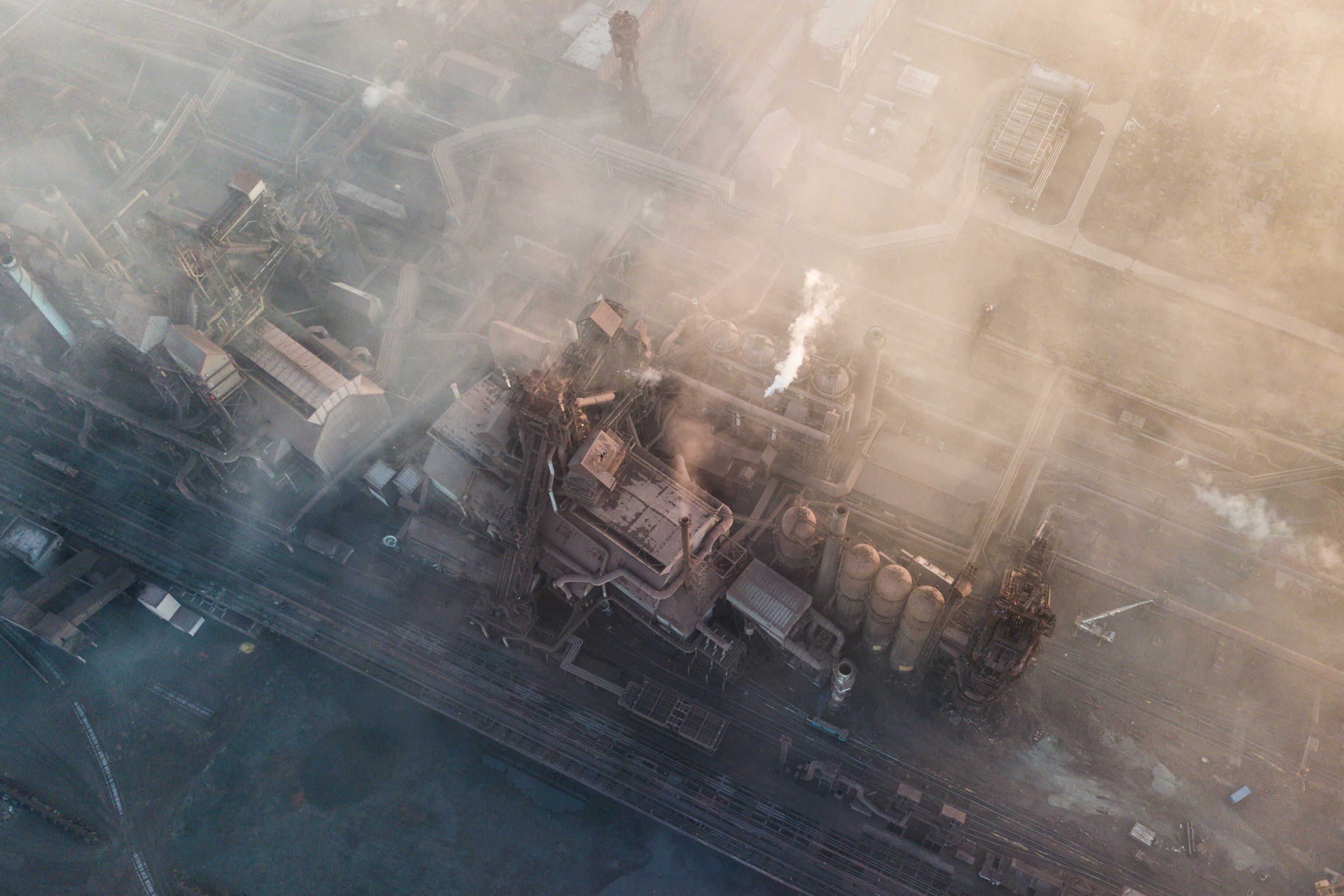 a view looking down at the smoking and dirty buildings of the azovstal plant