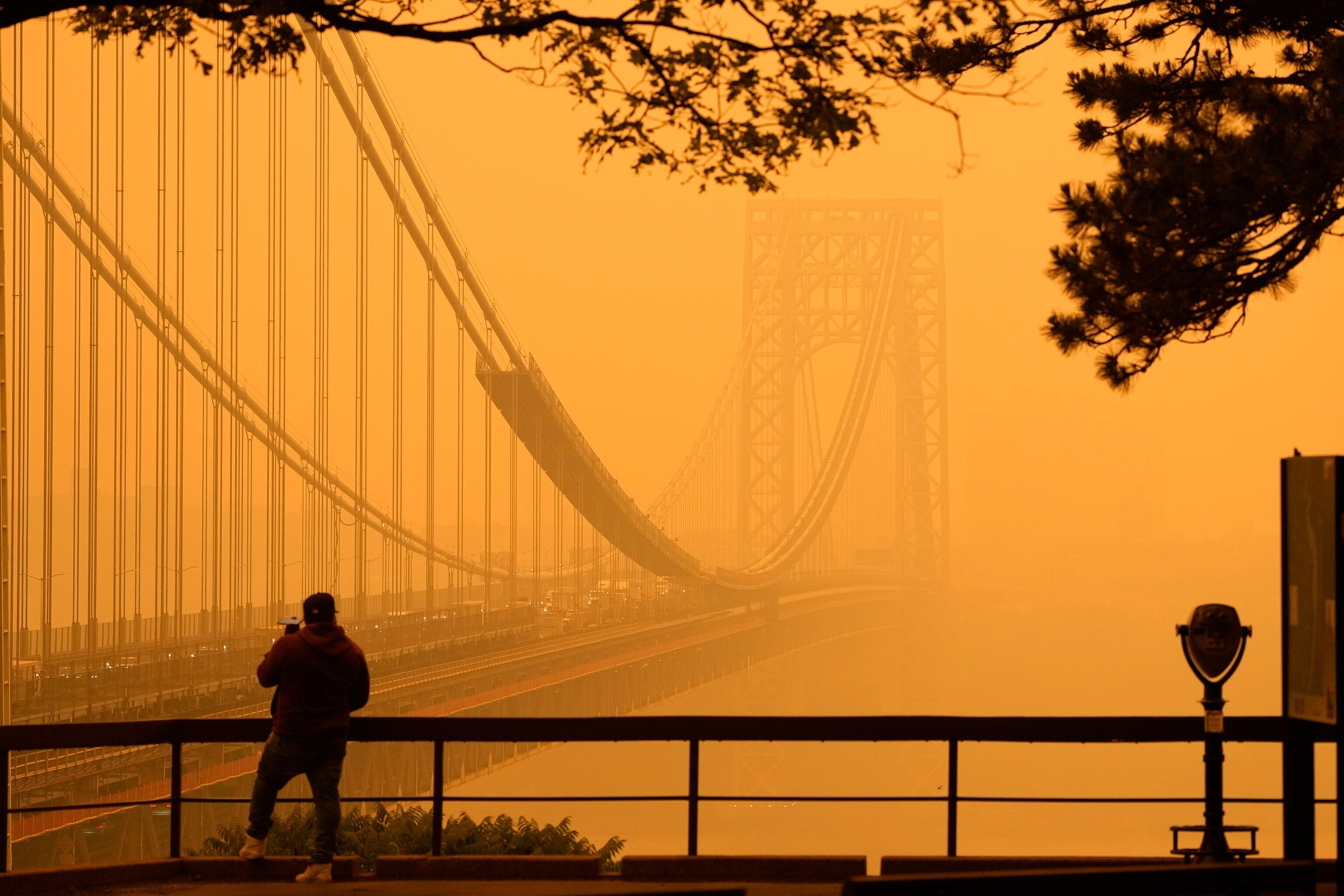 Deep orange and a thick haze make the George Washington Bridge less visable.