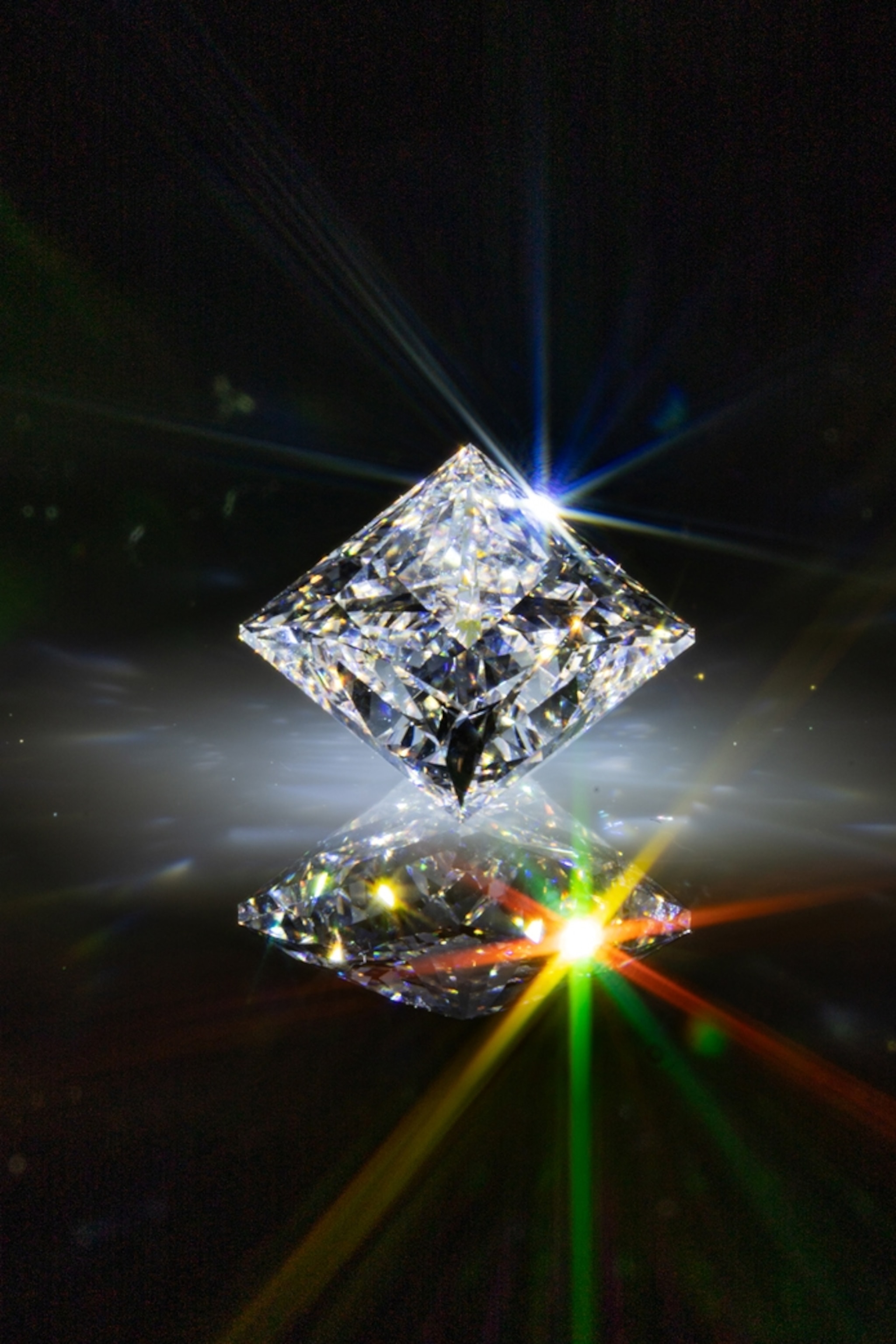 Polished diamond shining in dark and its reflection.