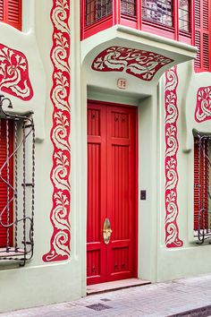 door at 75 Padua Street, Barcelona - art nouveau in soft green and saturated red (photo:  david cardelús - designboom)