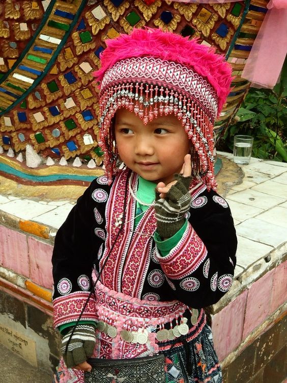 Chiang Mai, Thailand | This girl was standing on the staircase entering into Wat Phrathat Doi Suthep, a Buddhist temple in Chiang Mai. Her mother was sitting nearby, working on a stitched pattern to sell in the market. She is dressed in traditional Thai Hill Tribe clothing. |  Image and caption by Megan Jefferies