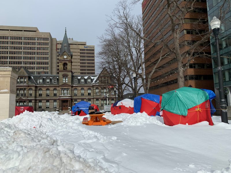 Red shelters and an orange picnic table in the deep snow in front of city hall in Halifax.